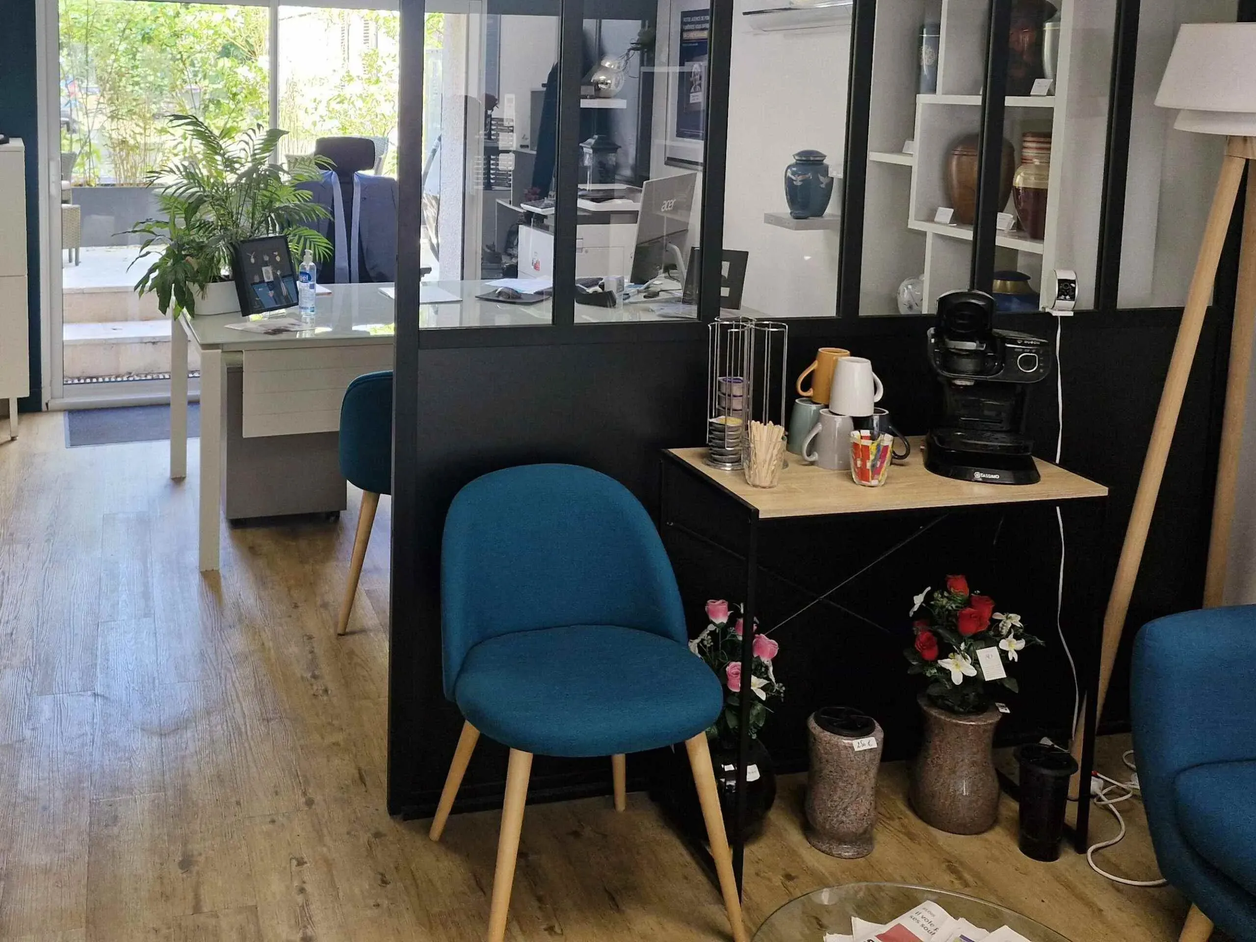 Entrée d'un bureau funéraire moderne avec des chaises et un comptoir de café.