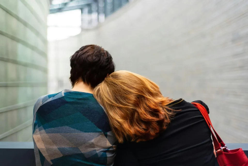Une femme pose sa tête sur l'épaule de son amie pour la réconforter dans la peine.